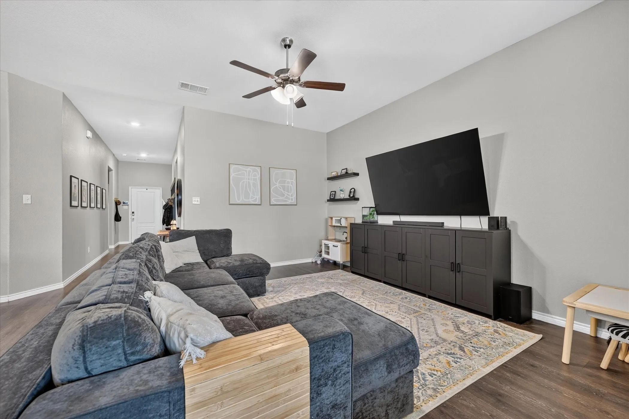 Wood-finish flooring throughout, complemented by light gray wall tones
