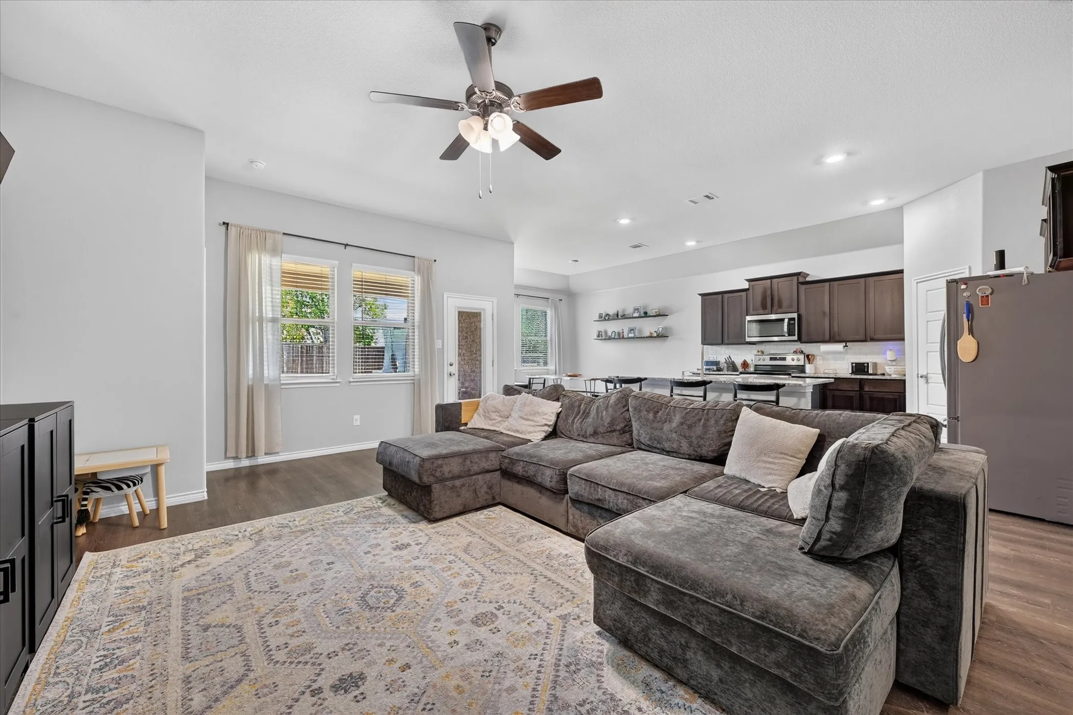 Open-concept living space featuring wood-finish flooring, recessed lighting, and a ceiling fan