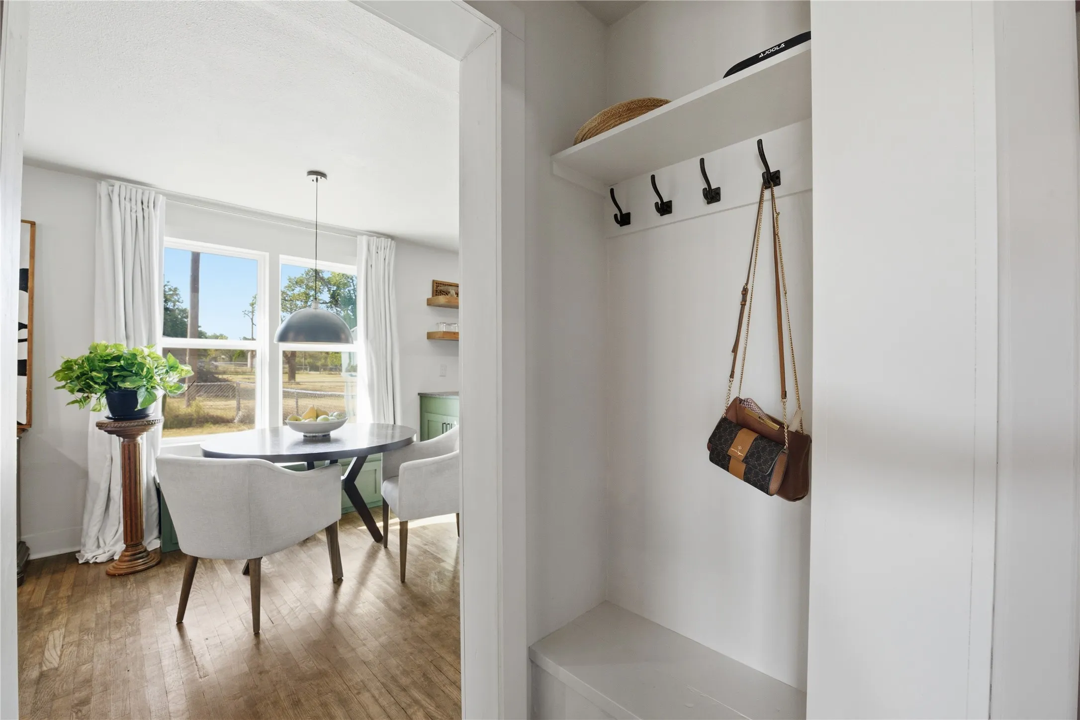 Built-in mudroom bench with coat hooks and overhead shelving