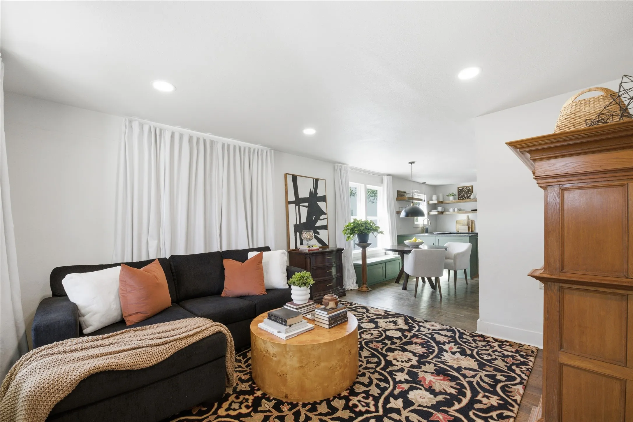 Recessed lighting illuminates the living space with wood-finish flooring