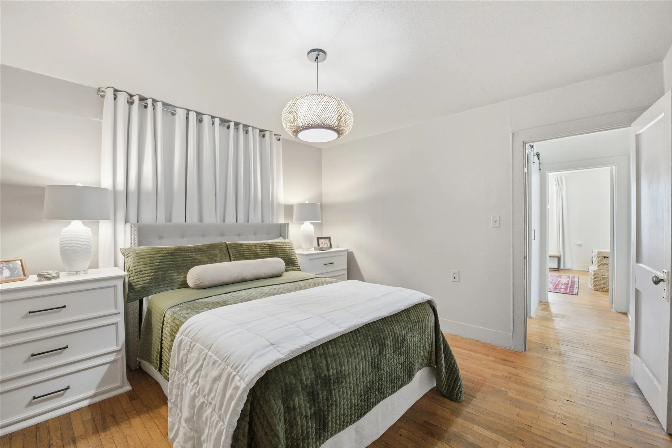 Hardwood flooring, white painted walls, and a light fixture