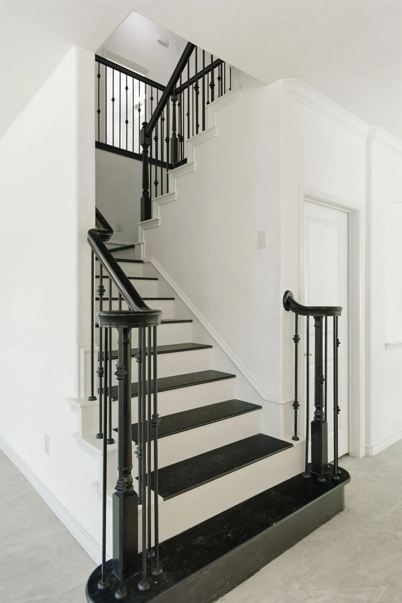 Two-story staircase with black treads and white risers