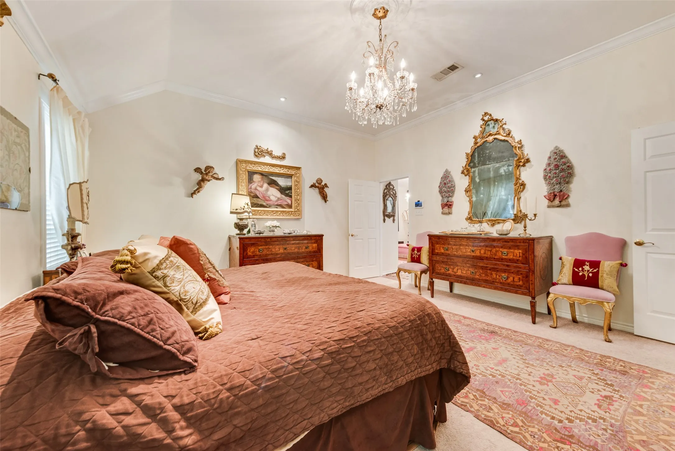 Vaulted ceiling with crown molding, chandelier, recessed lighting, white interior doors, and carpet flooring