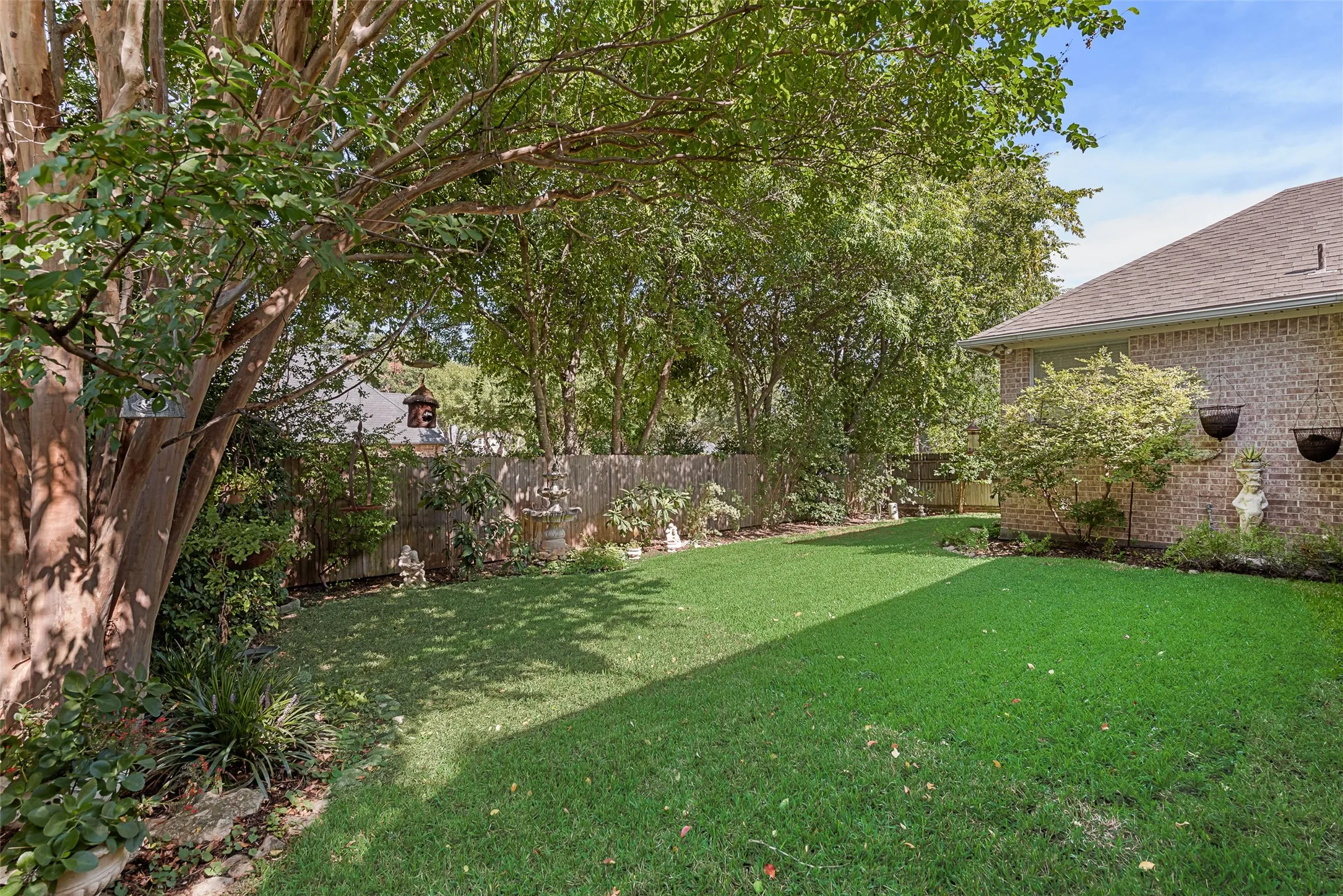 Expansive lawn area with mature trees and established perimeter landscaping