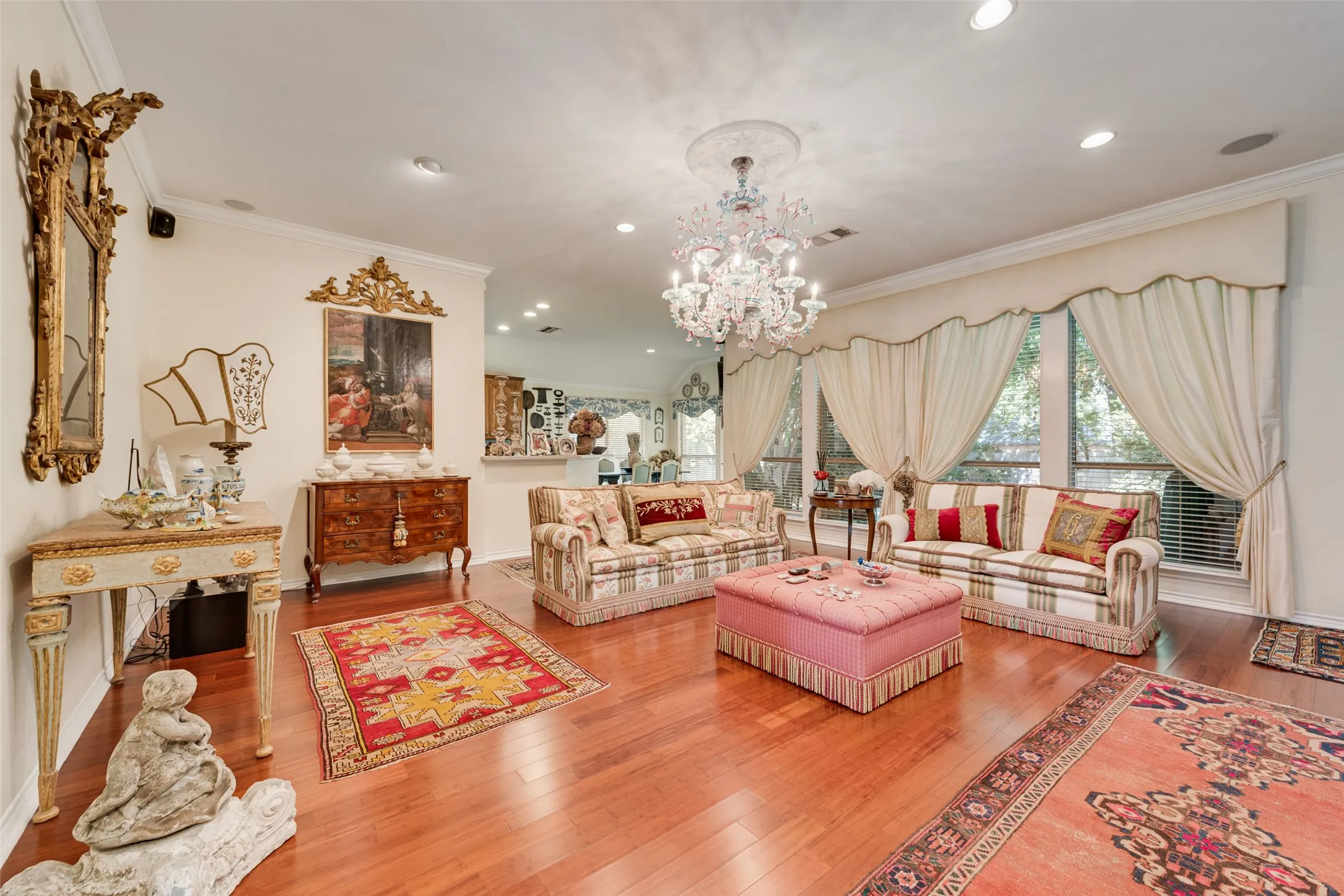 Hardwood flooring, crown molding, cased openings, and large windows