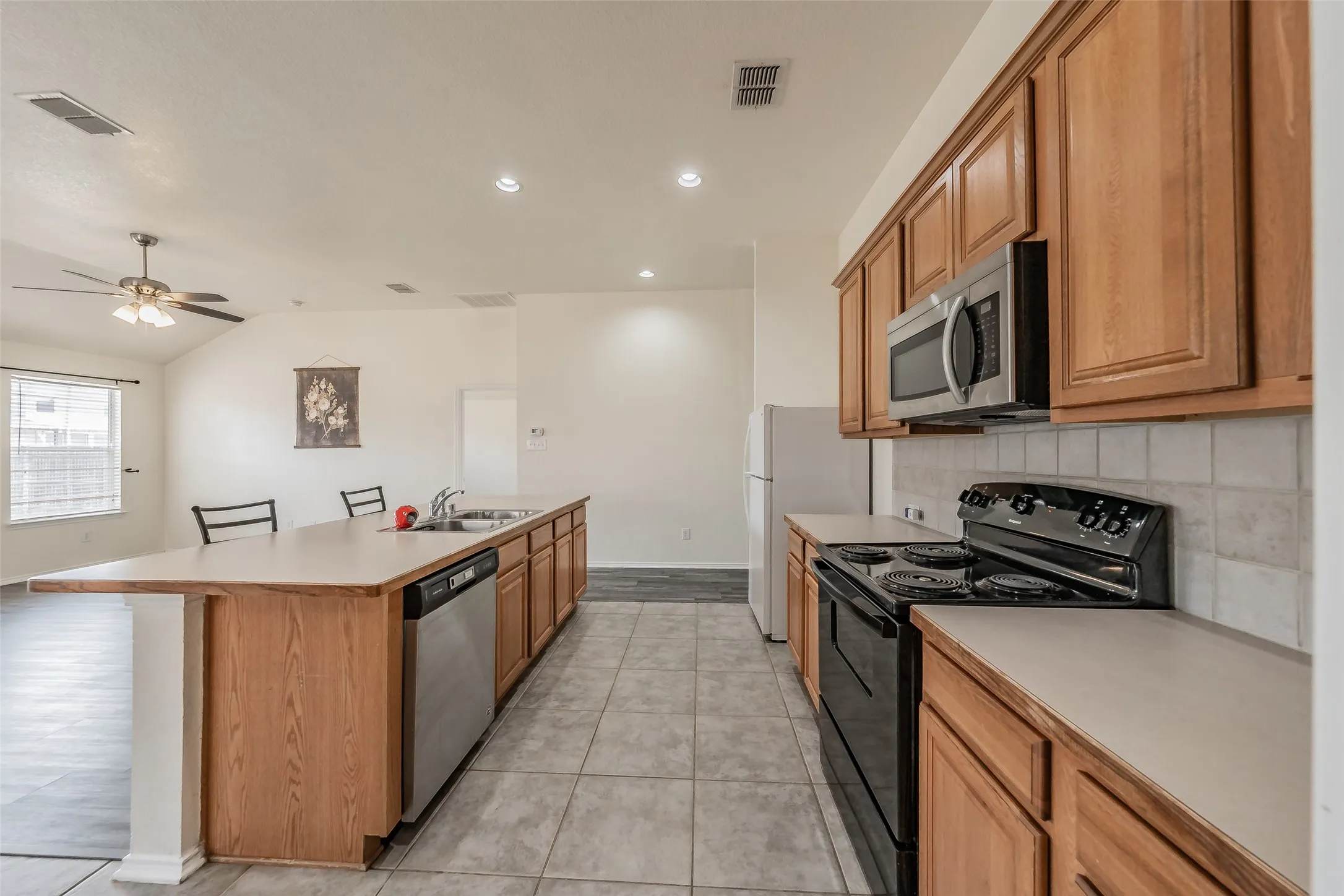 Spacious kitchen featuring ample cabinetry for storage and a sink that overlooks the living area.