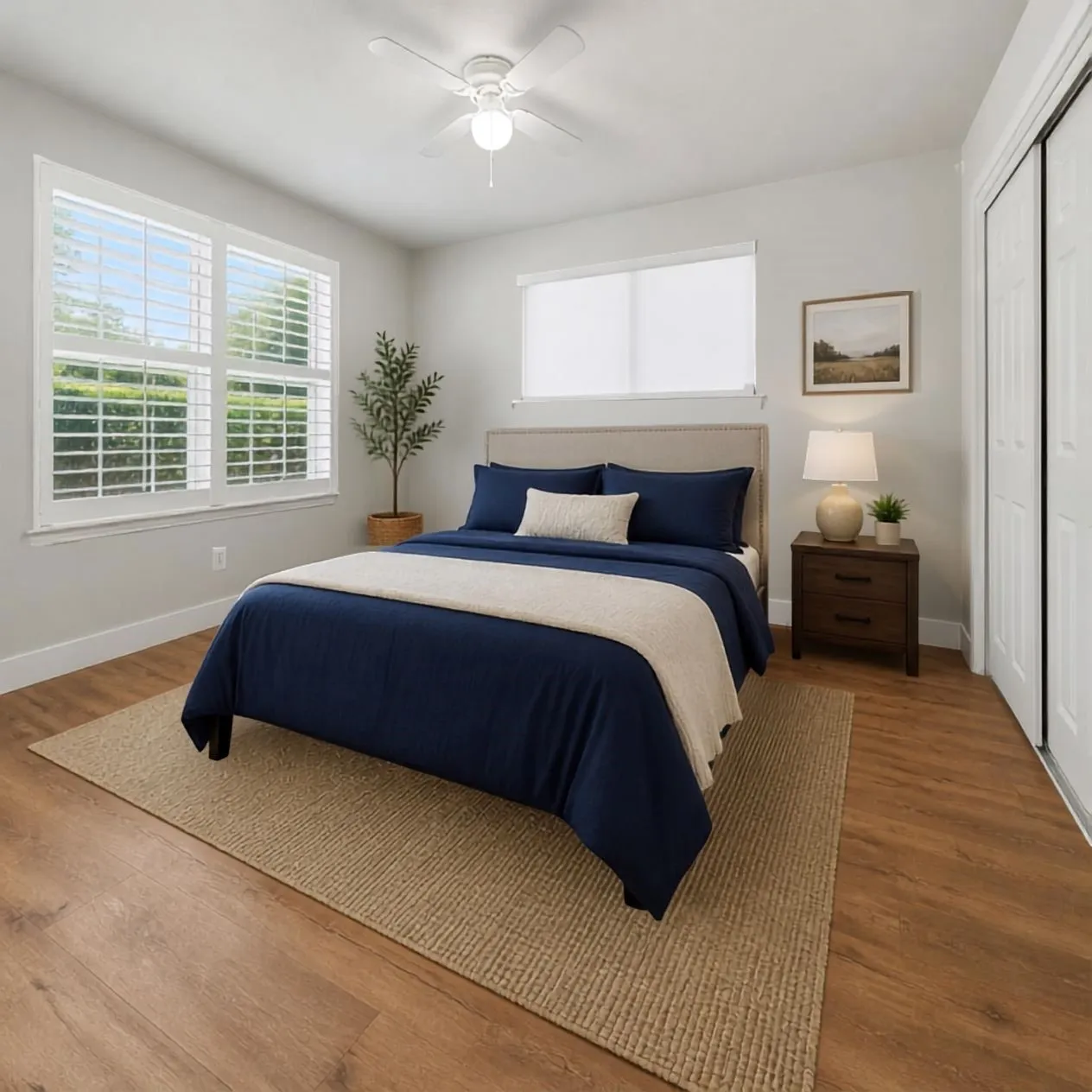 Virtually Staged Wood-finish flooring, ceiling fan, and large windows with plantation shutters