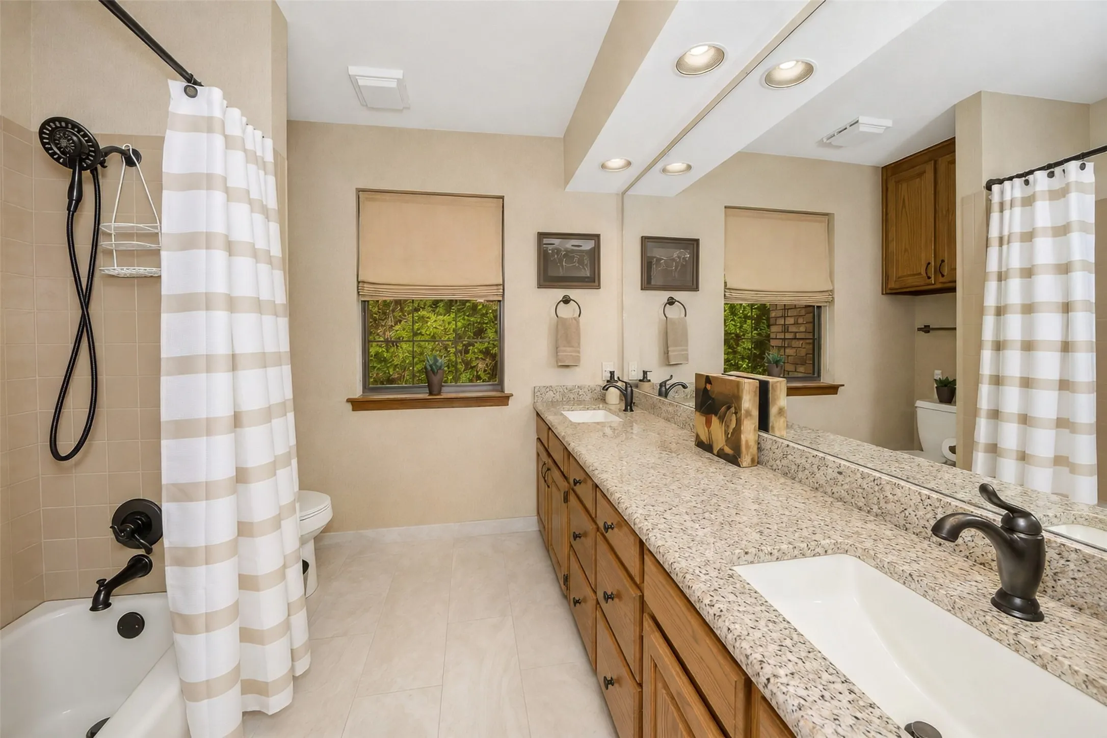 Guest bath has granite counter tops, updated flooring and a tiled tub/shower.