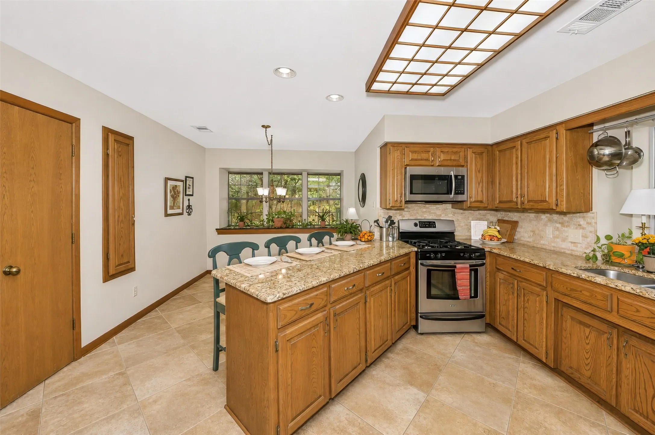 Lovely kitchen features wooden cabinetry, updated appliances and granite counter tops.