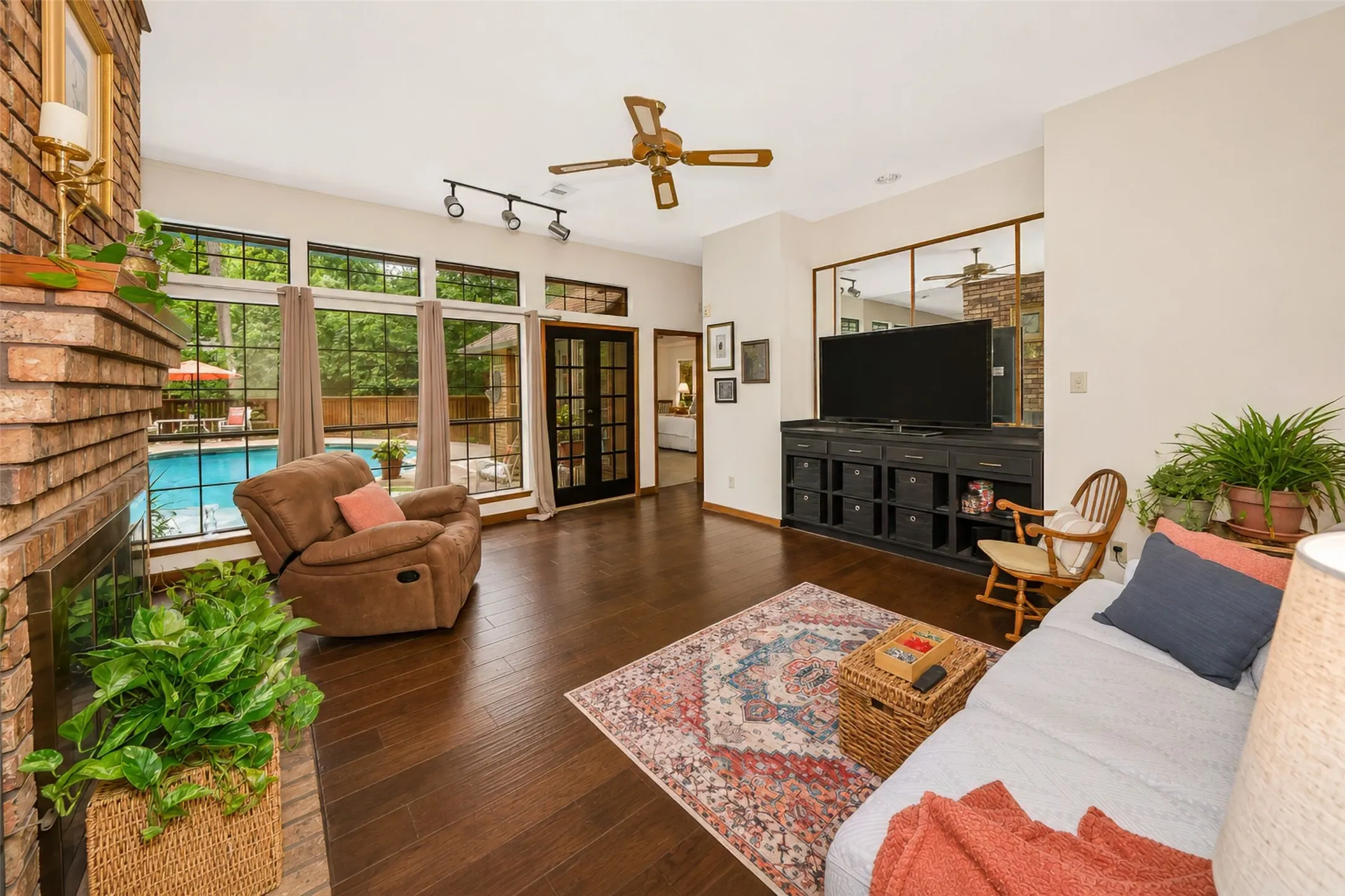 The family room shares a two sized fireplace and also overlooks the sparkling pool.