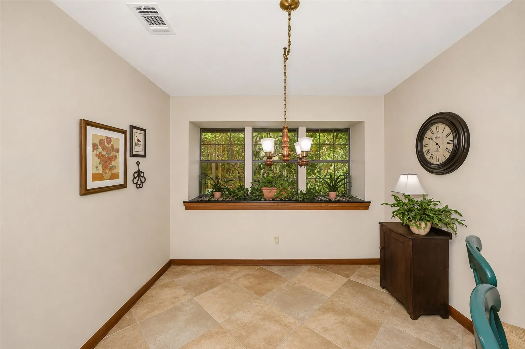 Breakfast area with large window overlooking trees and landscaping.