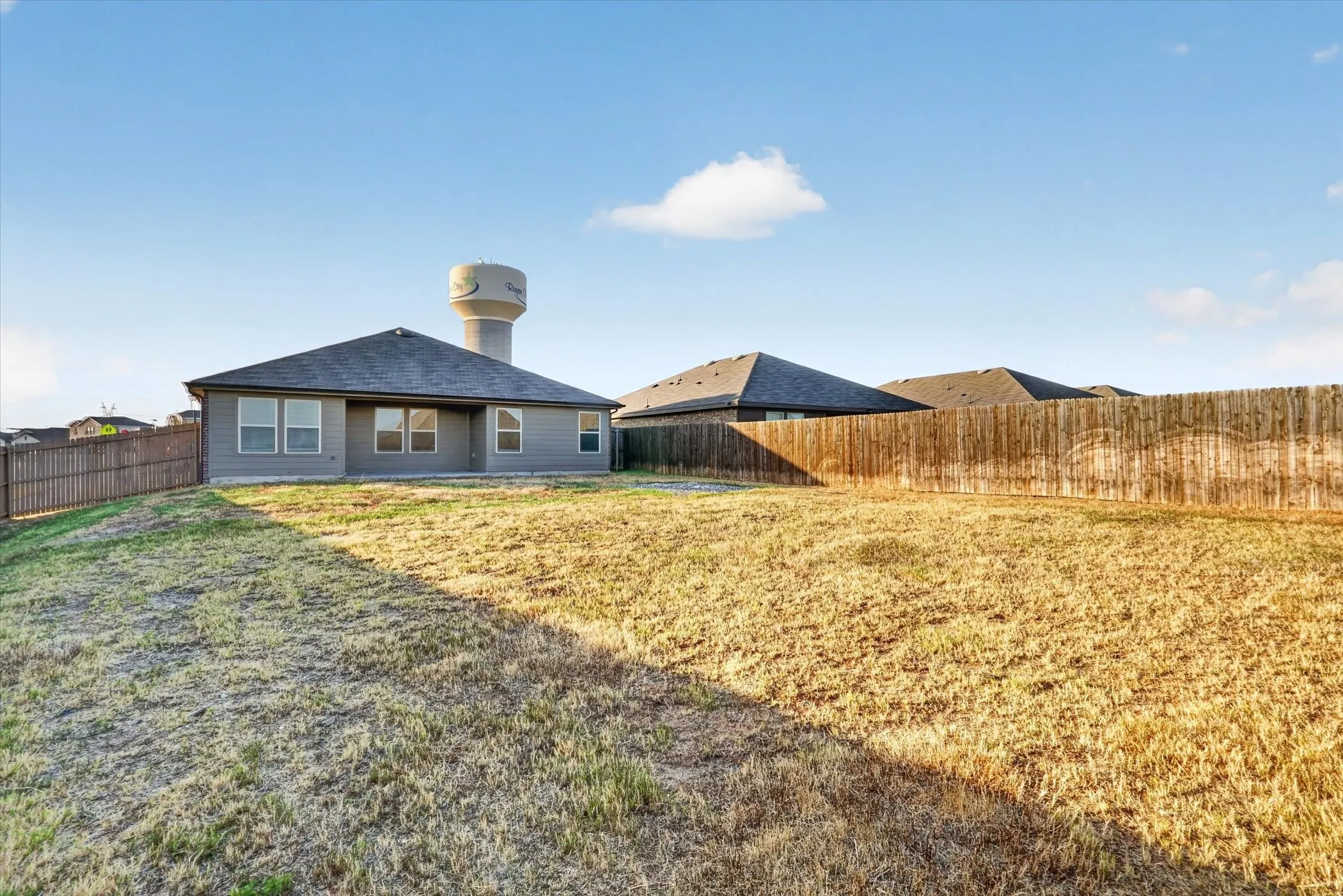 Spacious rear yard with a wood privacy fence