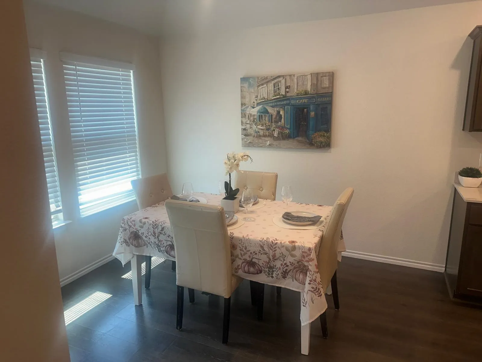 Intimate dining space featuring a wood-finish table, upholstered chairs, and abundant natural light from a multi-pane window