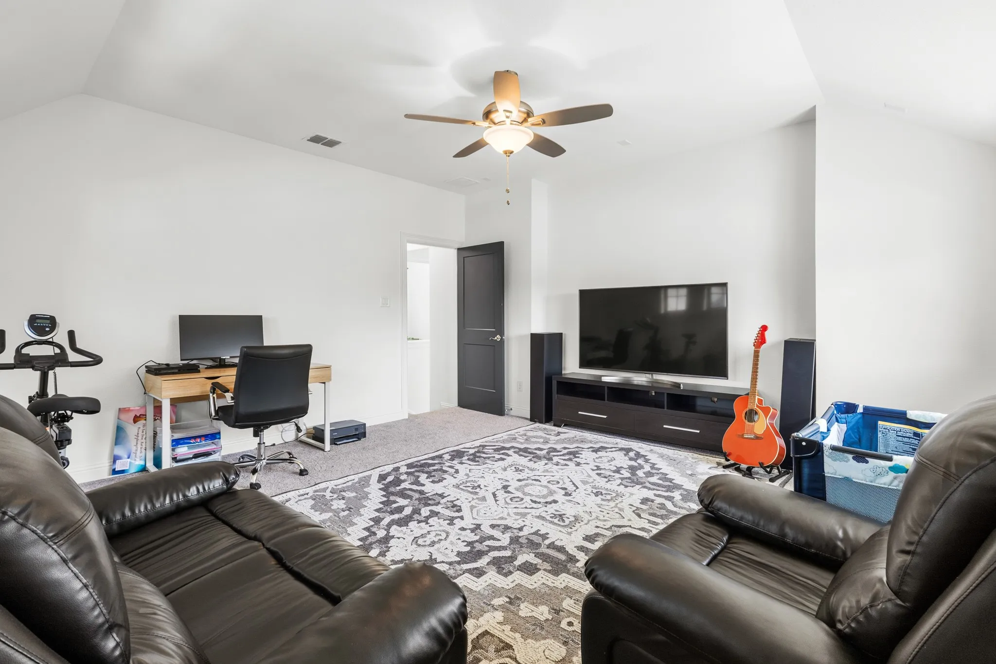 Vaulted ceiling, ceiling fan, recessed lighting, neutral wall paint, and gray carpet flooring