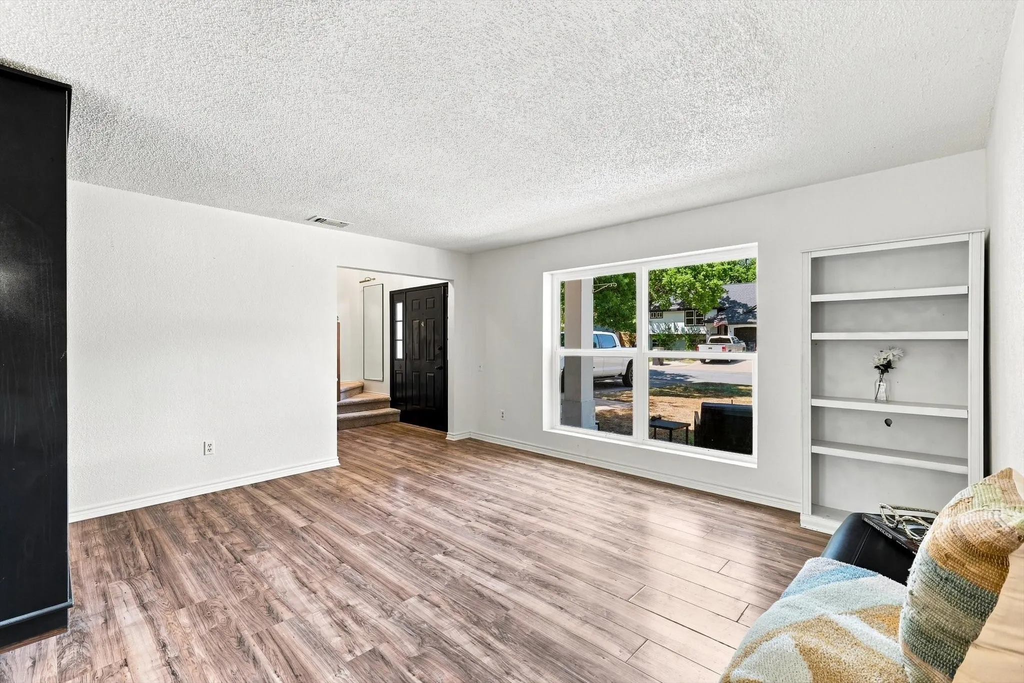Bright, spacious area with beautiful new flooring, built-in shelving, and abundant natural light.