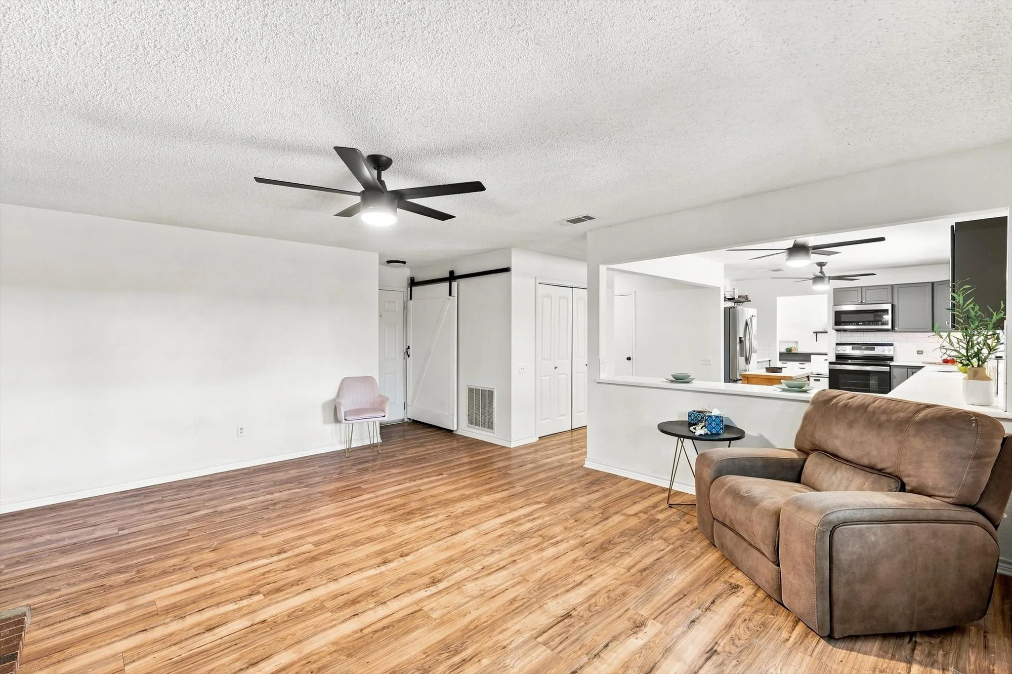 Open-concept living area with updated flooring and seamless flow into the kitchen.