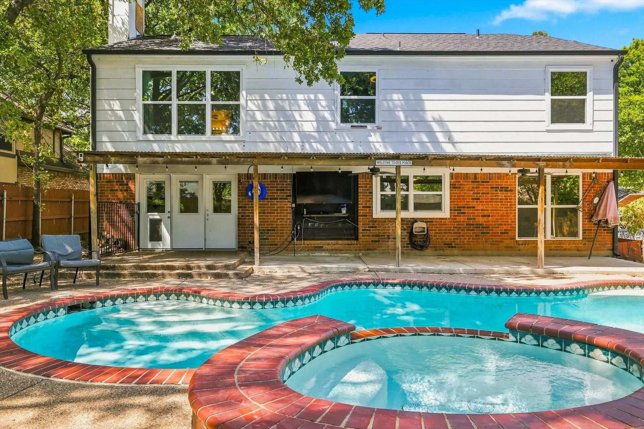 Backyard retreat featuring a sparkling pool, spa, and spacious covered patio.