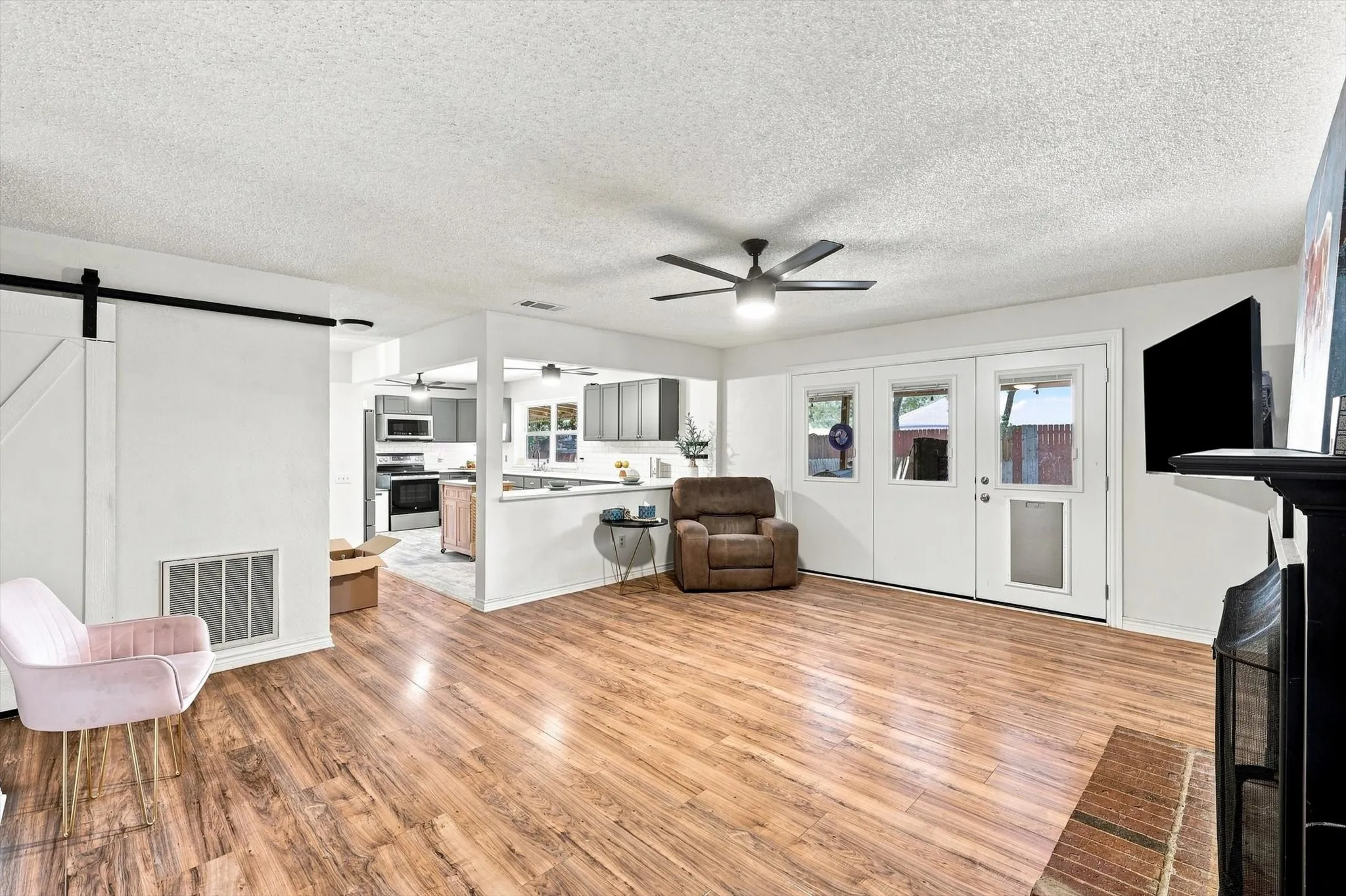 Spacious open-concept living area with fireplace, updated flooring, and easy flow into the kitchen.