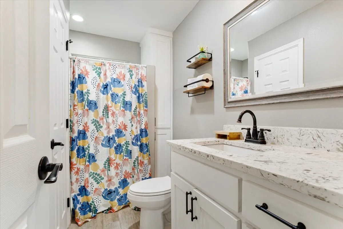 Vanity with a light-toned countertop, integrated sink, and dark-finished faucet