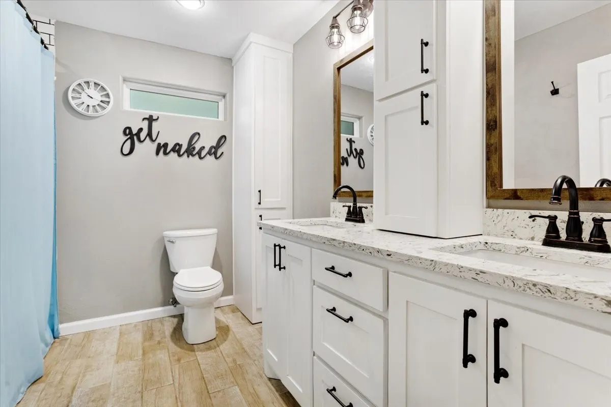 Dual vanity with white cabinetry, speckled countertops, and individual rectangular undermount sinks