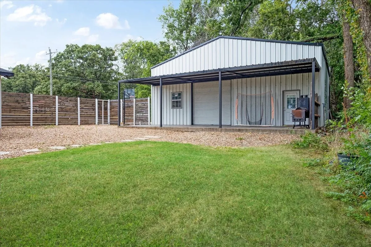 Metal-sided 40x40 building with a covered patio, roll-up door, and separate entry door