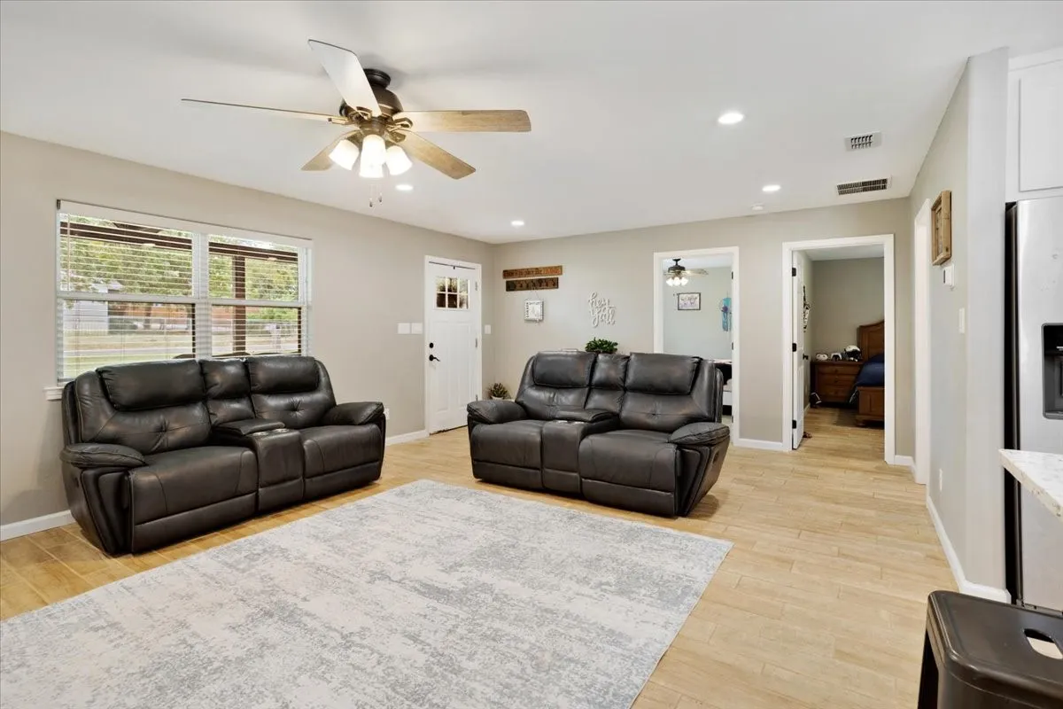 Recessed lighting, ceiling fan, wood-finish flooring, white paneled door with glass inserts, and light-toned walls