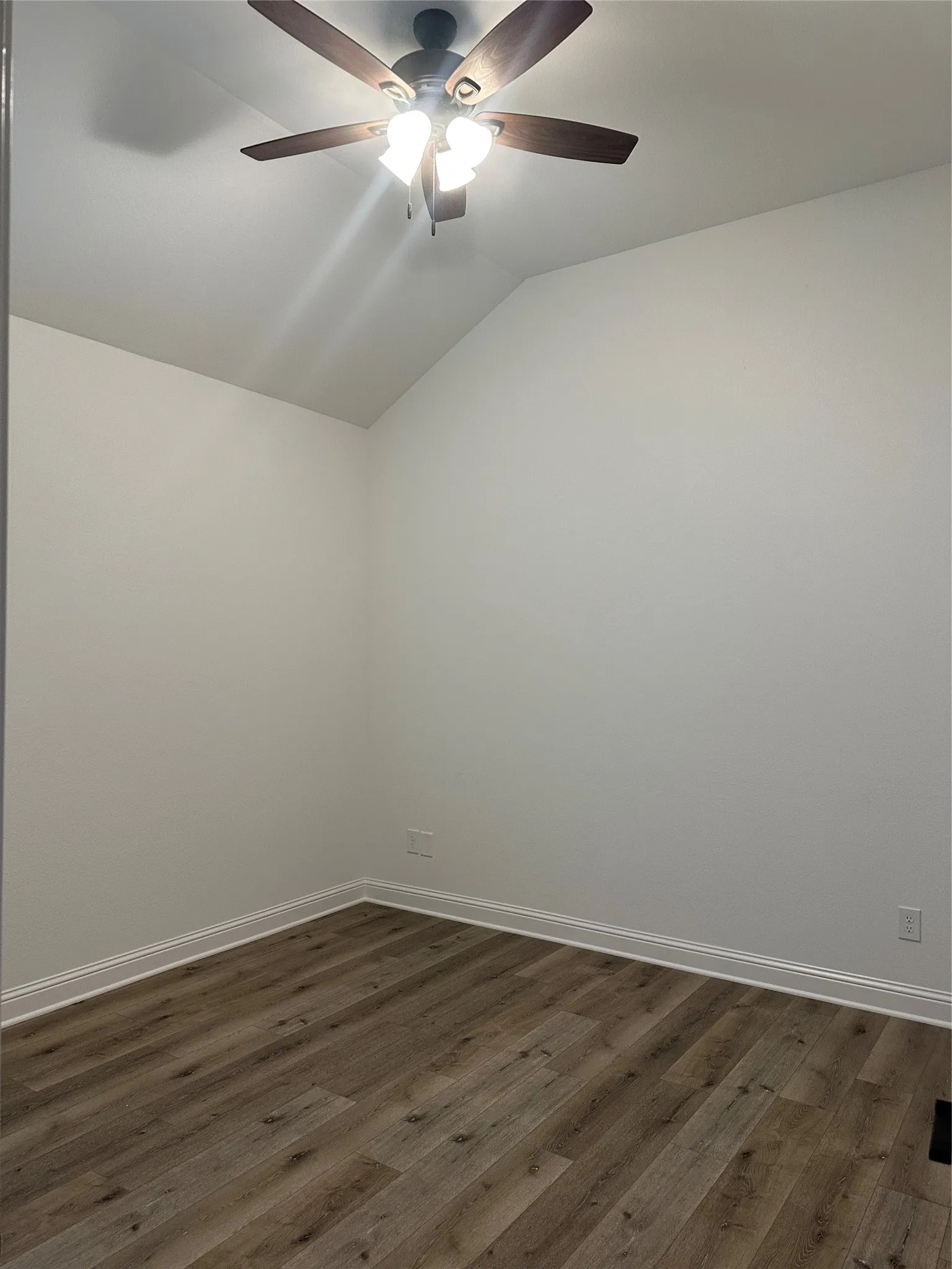 Vaulted ceiling with a ceiling fan featuring integrated lighting