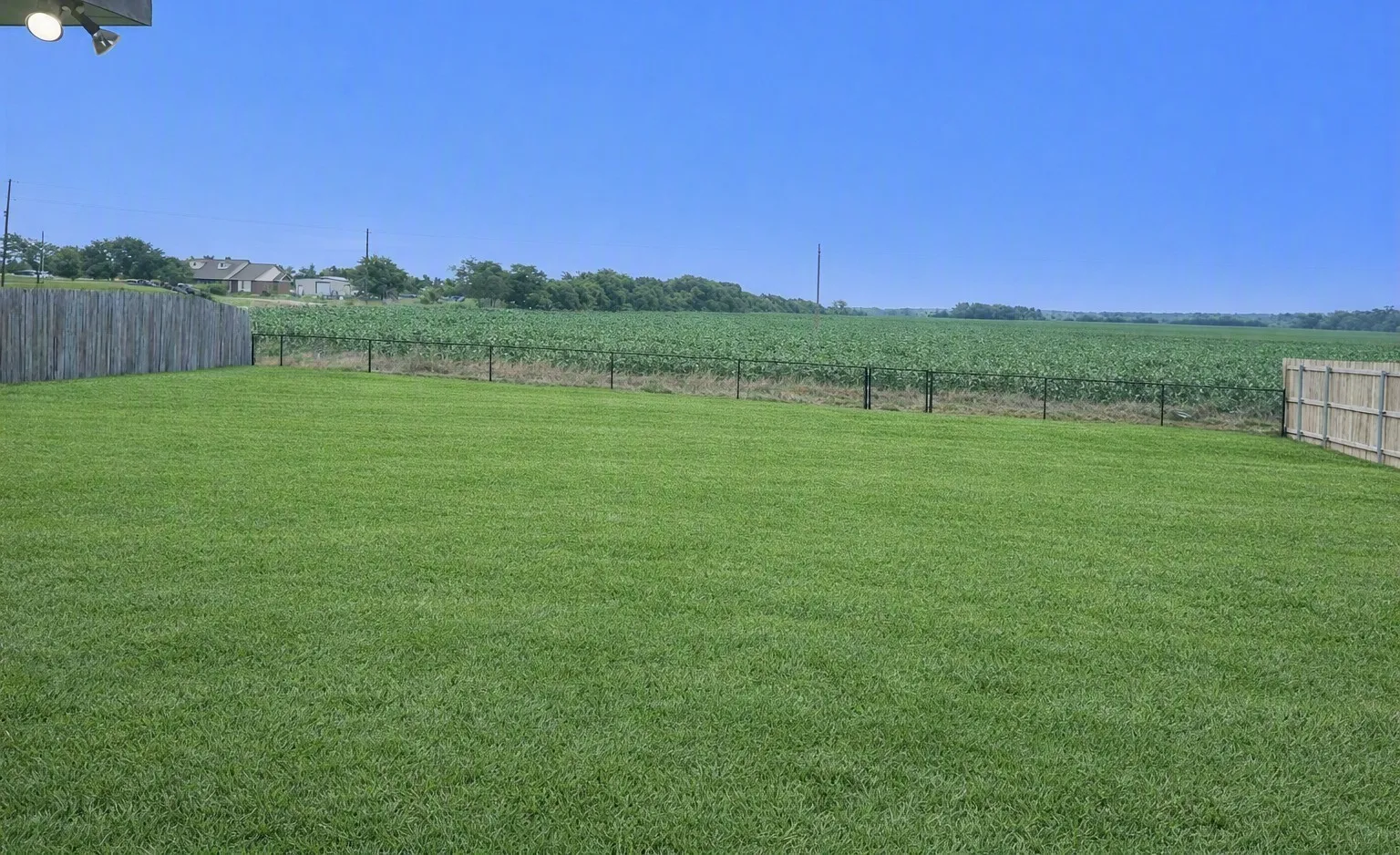Expansive lawn area with a wood privacy fence and a chain link fence