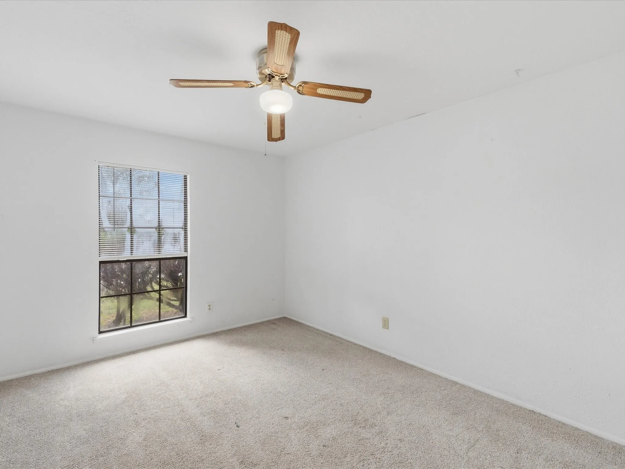 Recessed window, ceiling fan with integrated lighting, and neutral carpeting
