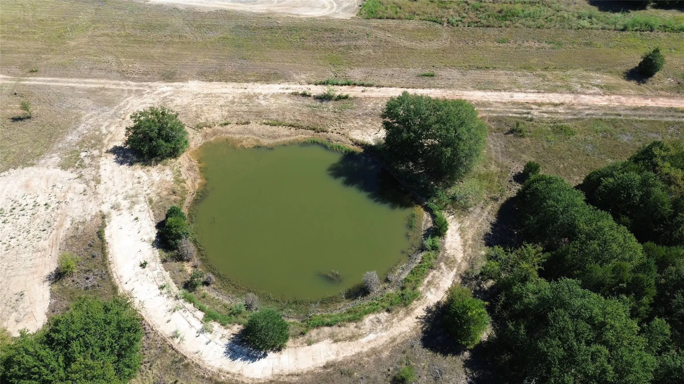 Natural water feature with surrounding trees and undeveloped land
