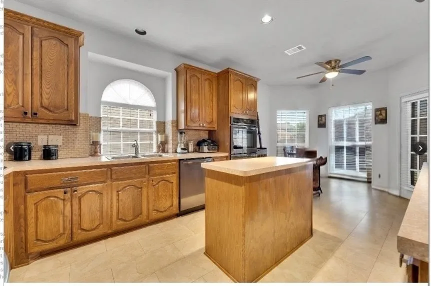 Kitchen featuring wood cabinetry, a central island, tile flooring, and integrated stainless steel appliances