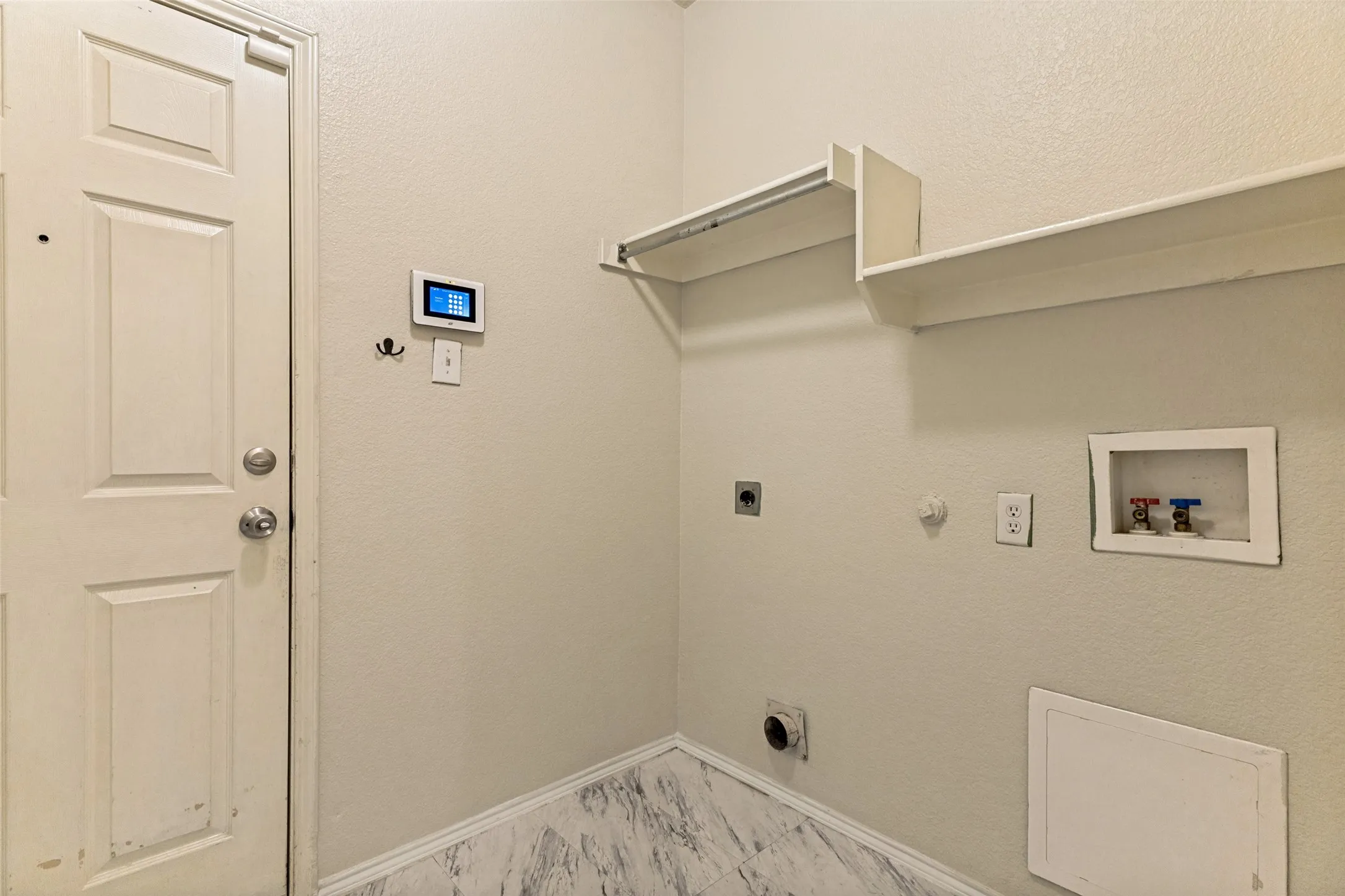 Laundry area featuring utility connections, an upper shelf, and wood-finish flooring