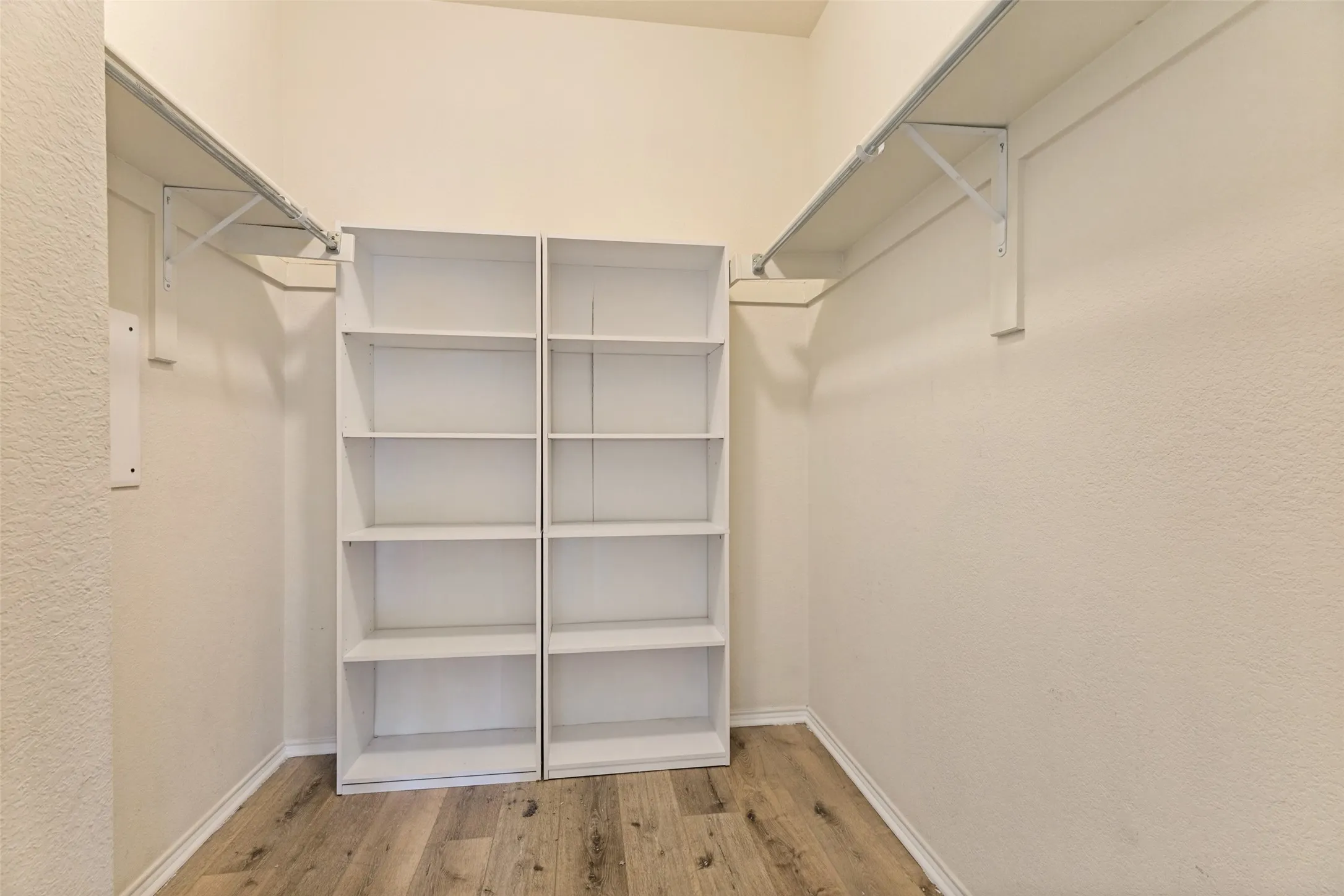 Built-in shelving units, integrated clothing rods, and wood-finish flooring