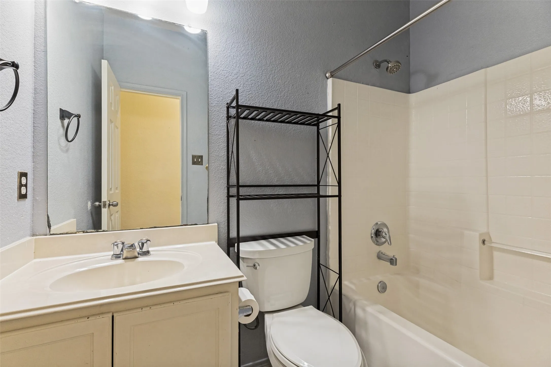 White vanity with integrated sink, chrome faucet, and mirrored wall