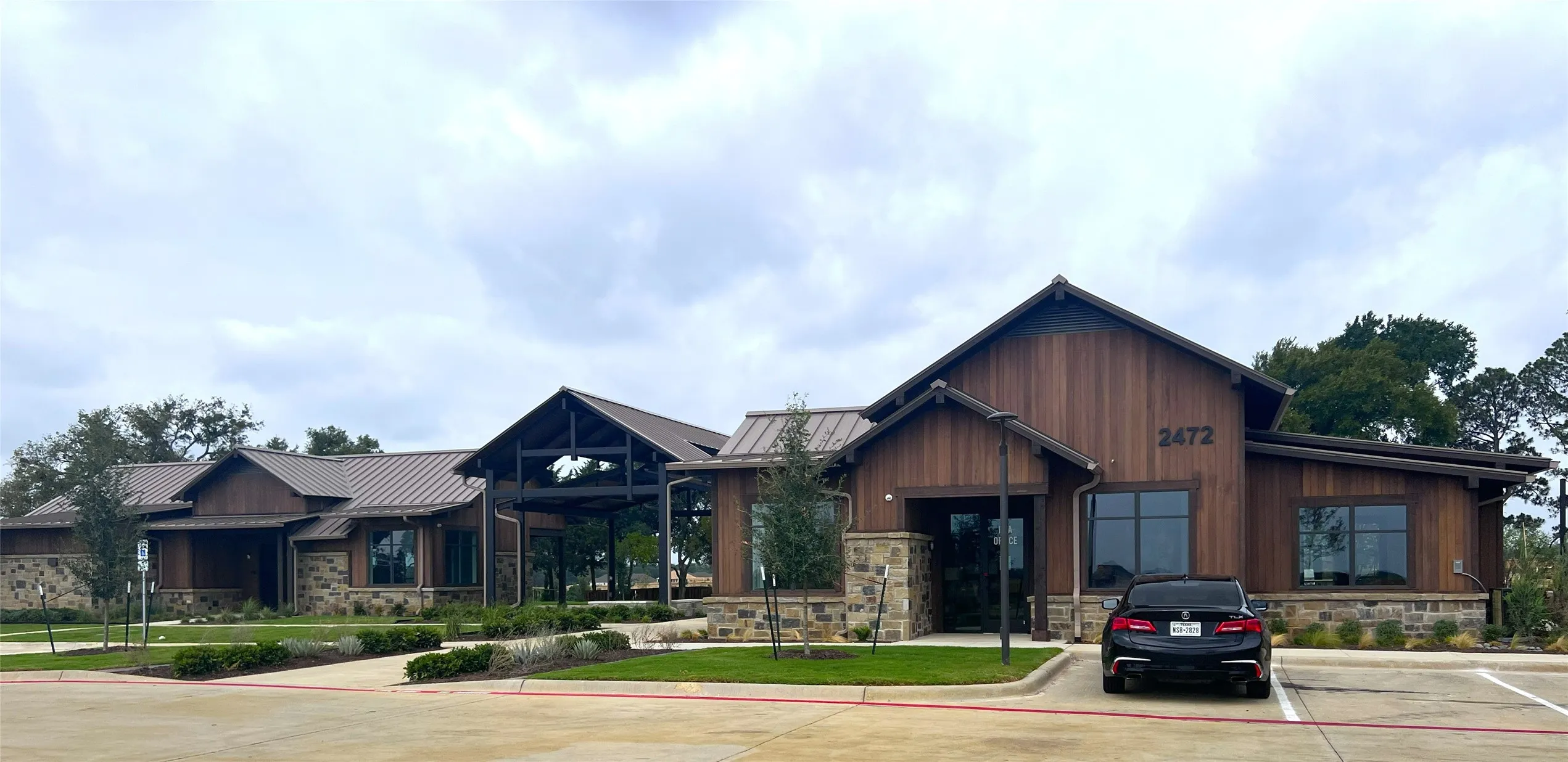 Wood-sided exterior with stone accents, featuring multiple gabled rooflines, a covered entry, and expansive windows