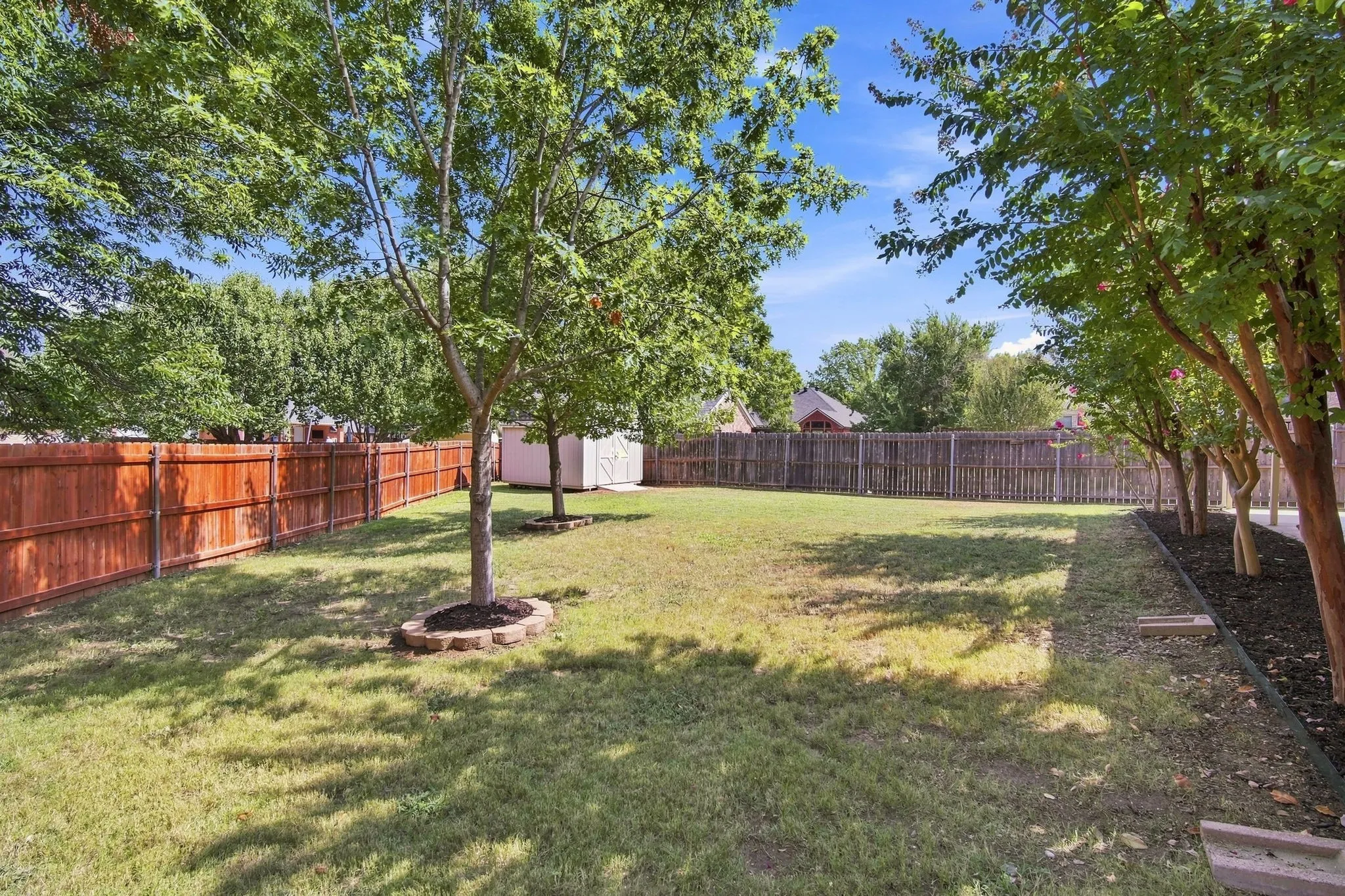 Backyard is well maintained with mature trees and room to run.
