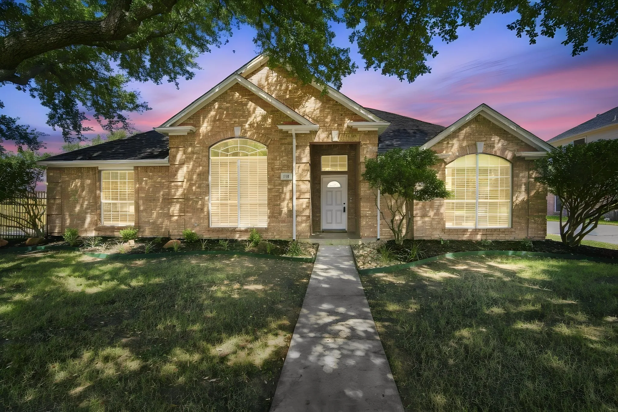 Professionally landscaped with flower beds, shrubs and mature trees.