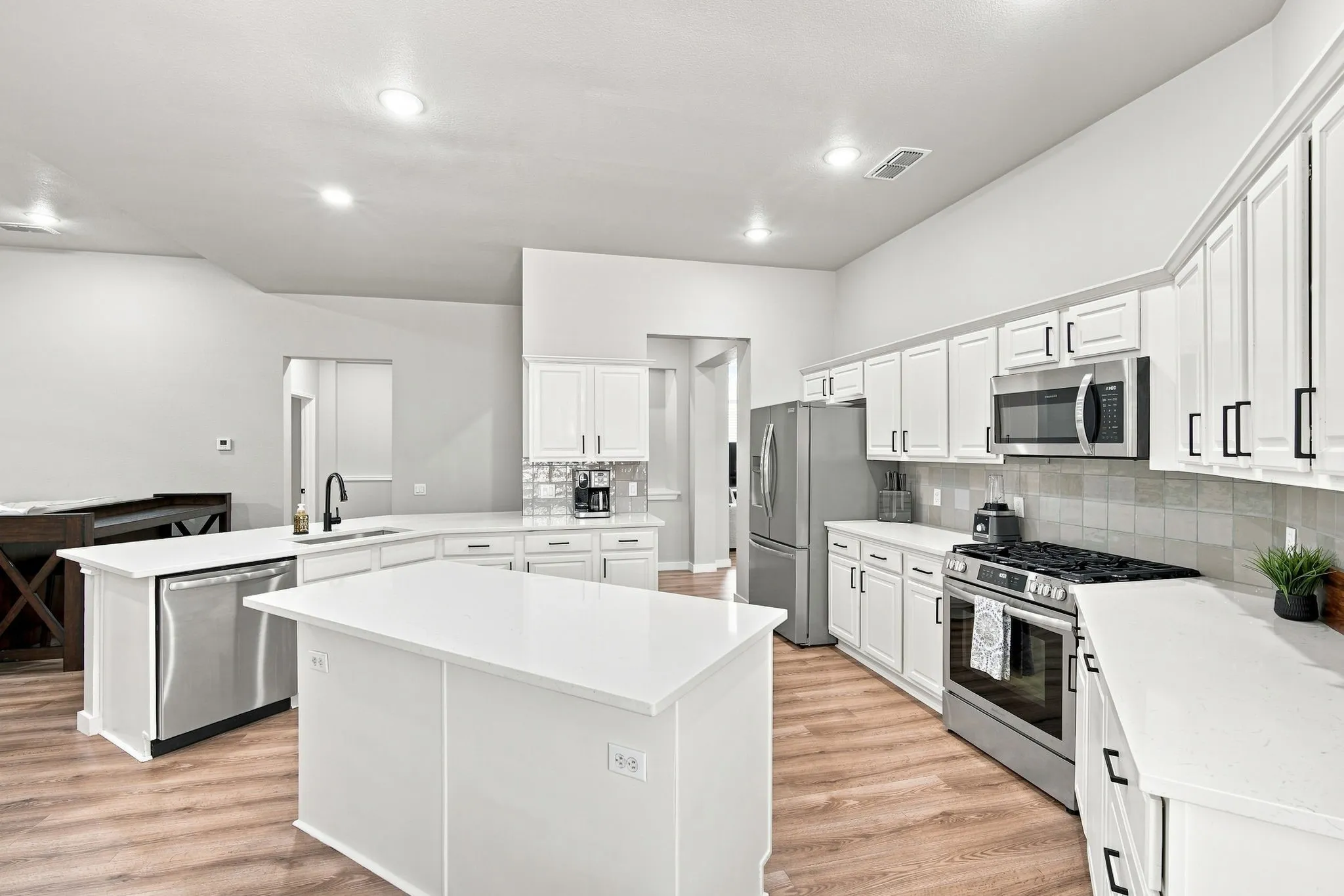 Cook's kitchen enhanced with loads of cabinetry, upgrade appliances with GAS stove, light counters and designer backsplash.