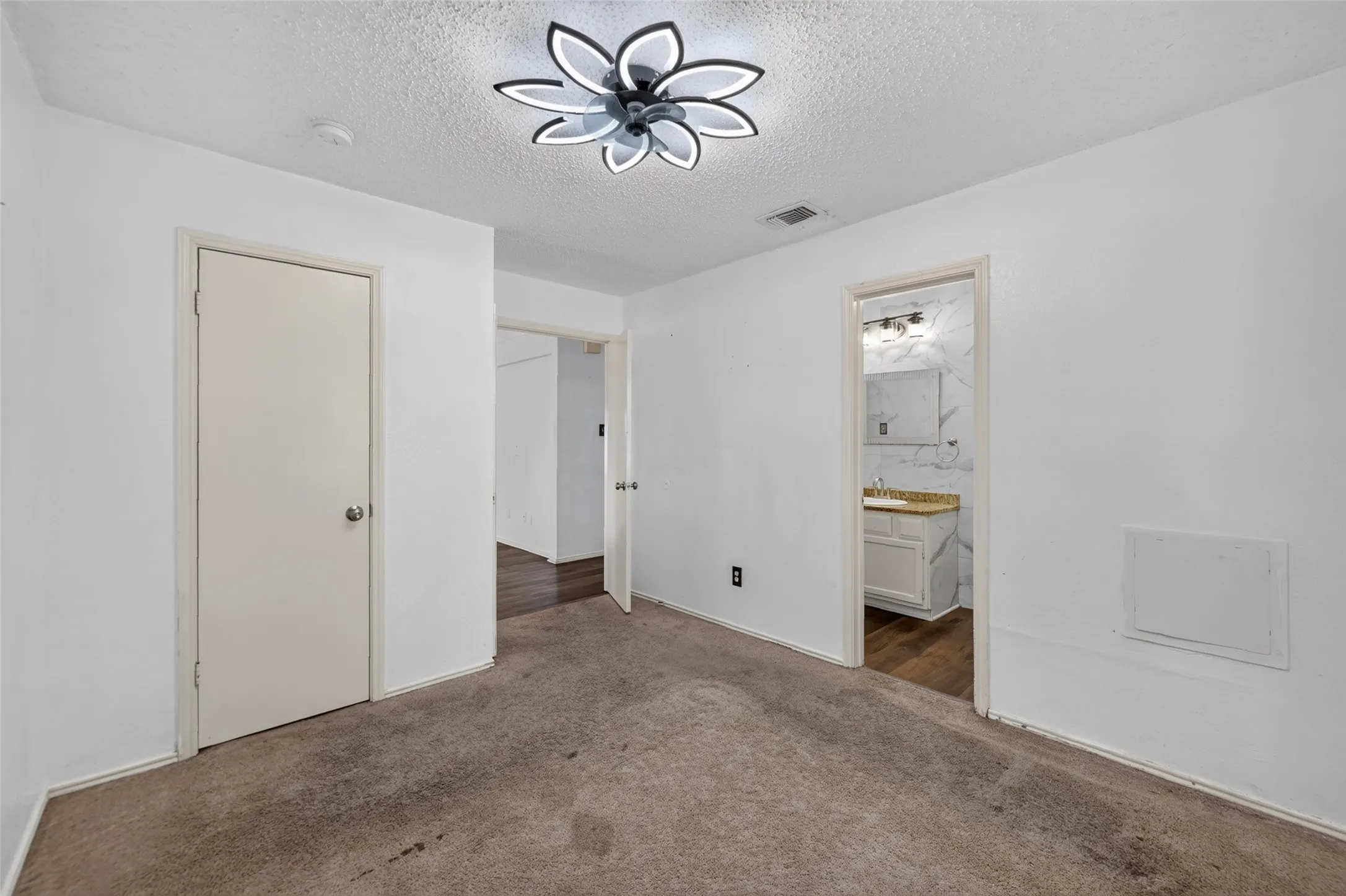 White walls, carpeted flooring, and a contemporary ceiling light fixture