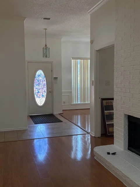 Entry foyer with a stained glass door and polished wood-finish flooring