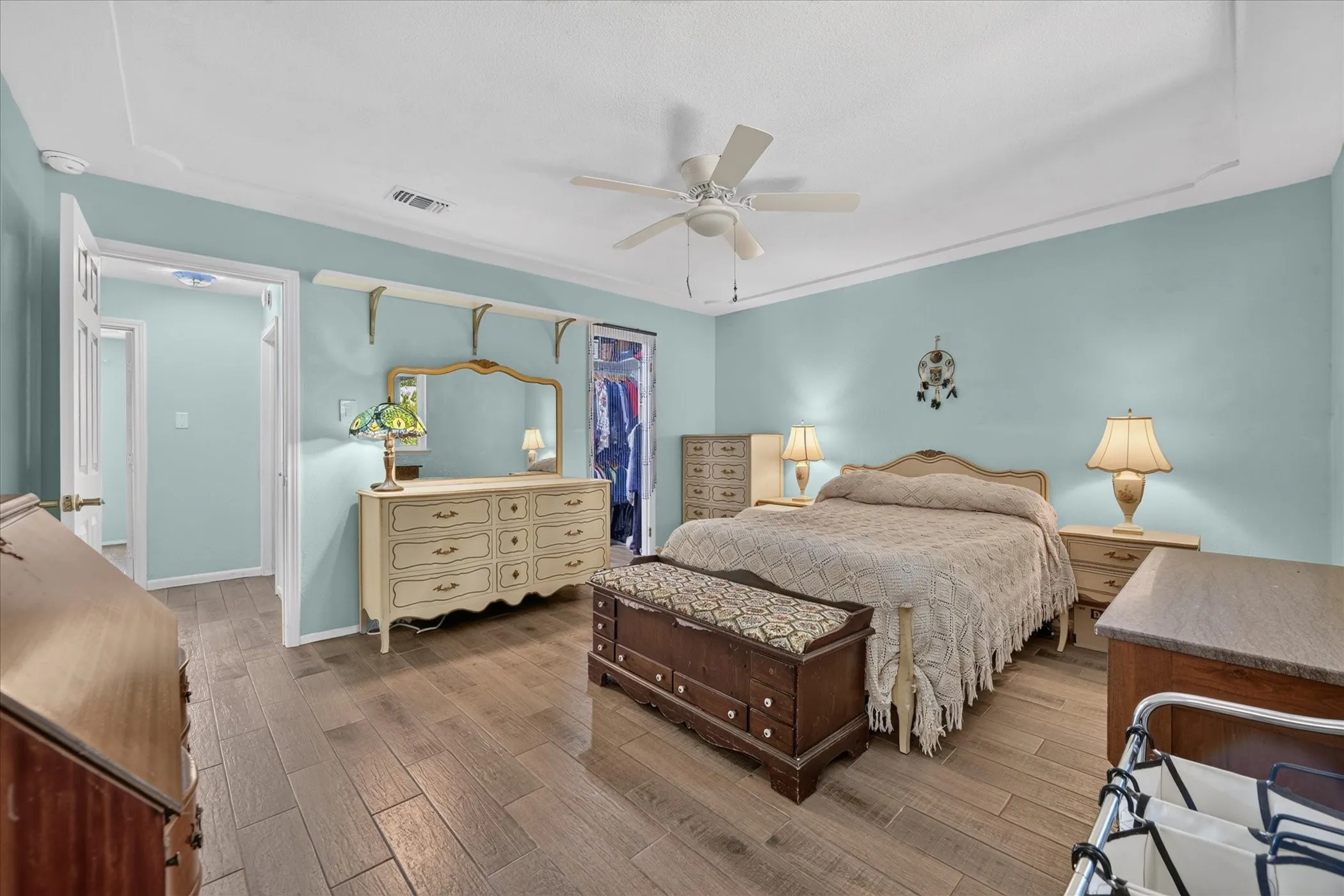 Wood-finish flooring throughout, tray ceiling, and a ceiling fan with integrated lighting