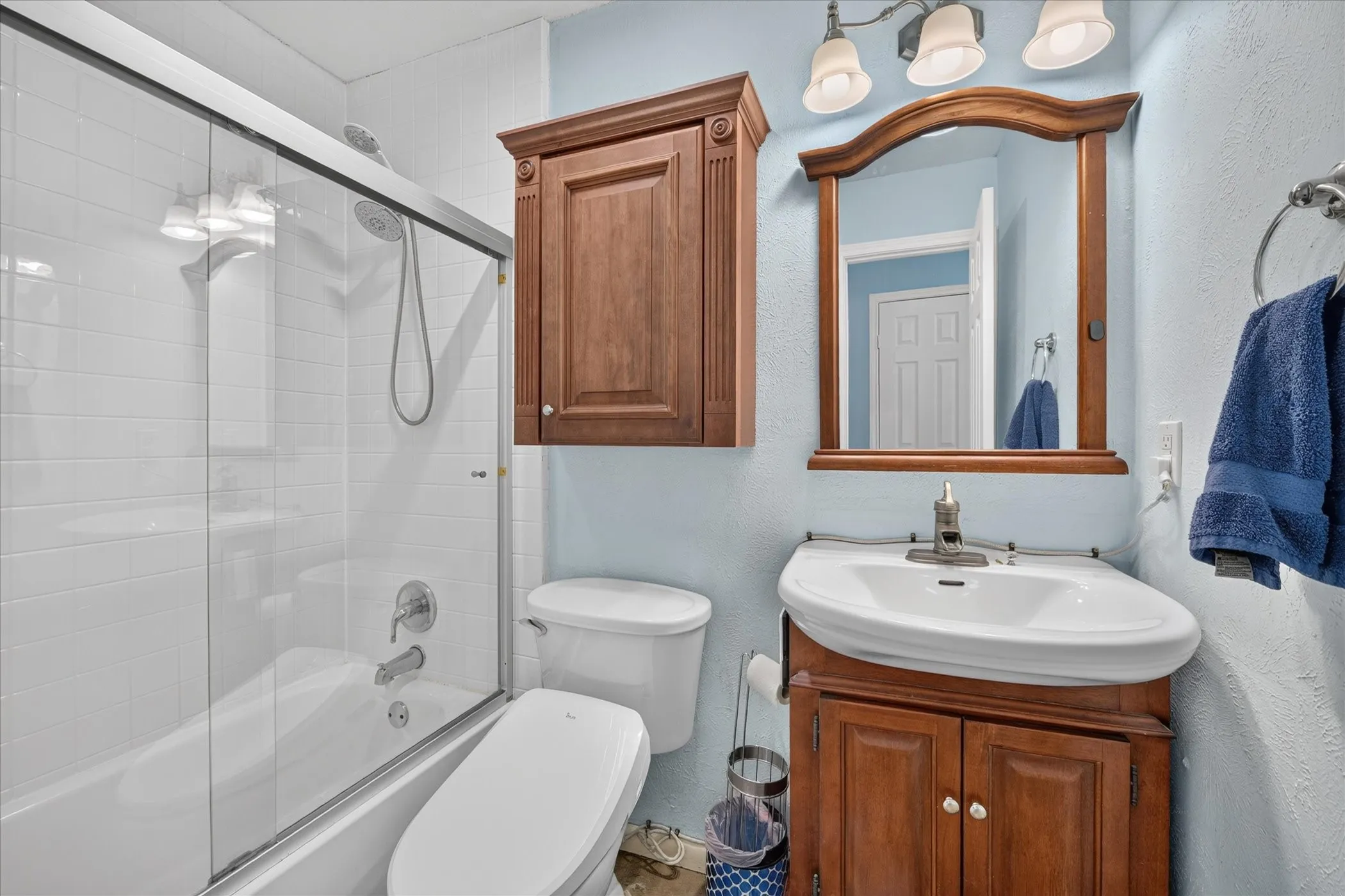 White subway tile bath enclosure with sliding glass door