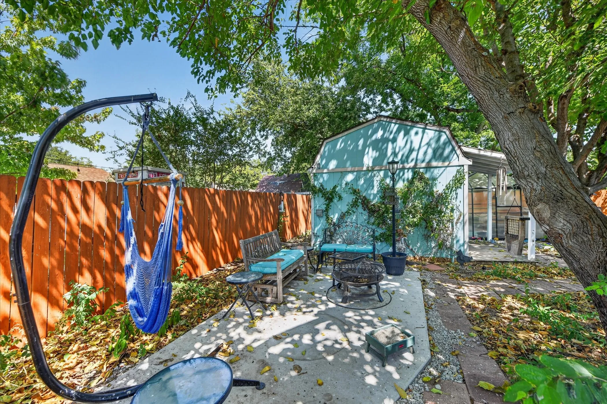 Paved patio area, mature trees, privacy fencing, detached storage shed, covered outdoor structure