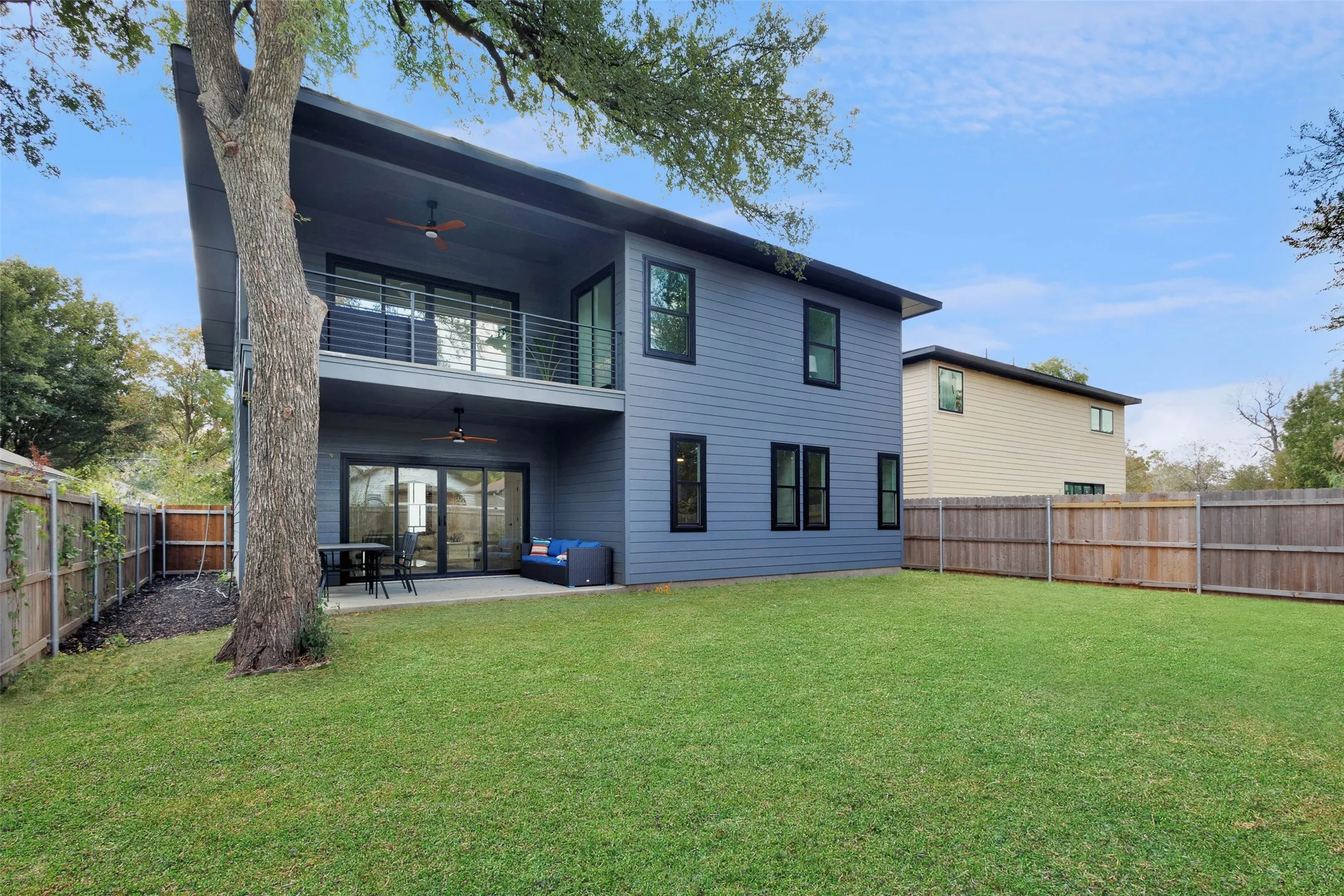 Expansive rear yard with full privacy fencing, and mature trees