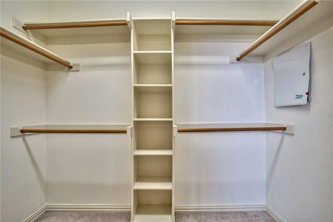 Custom closet organization system featuring shelving and hanging rods