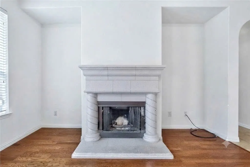 Fireplace with stone surround and hearth, fluted columns, and arched alcoves