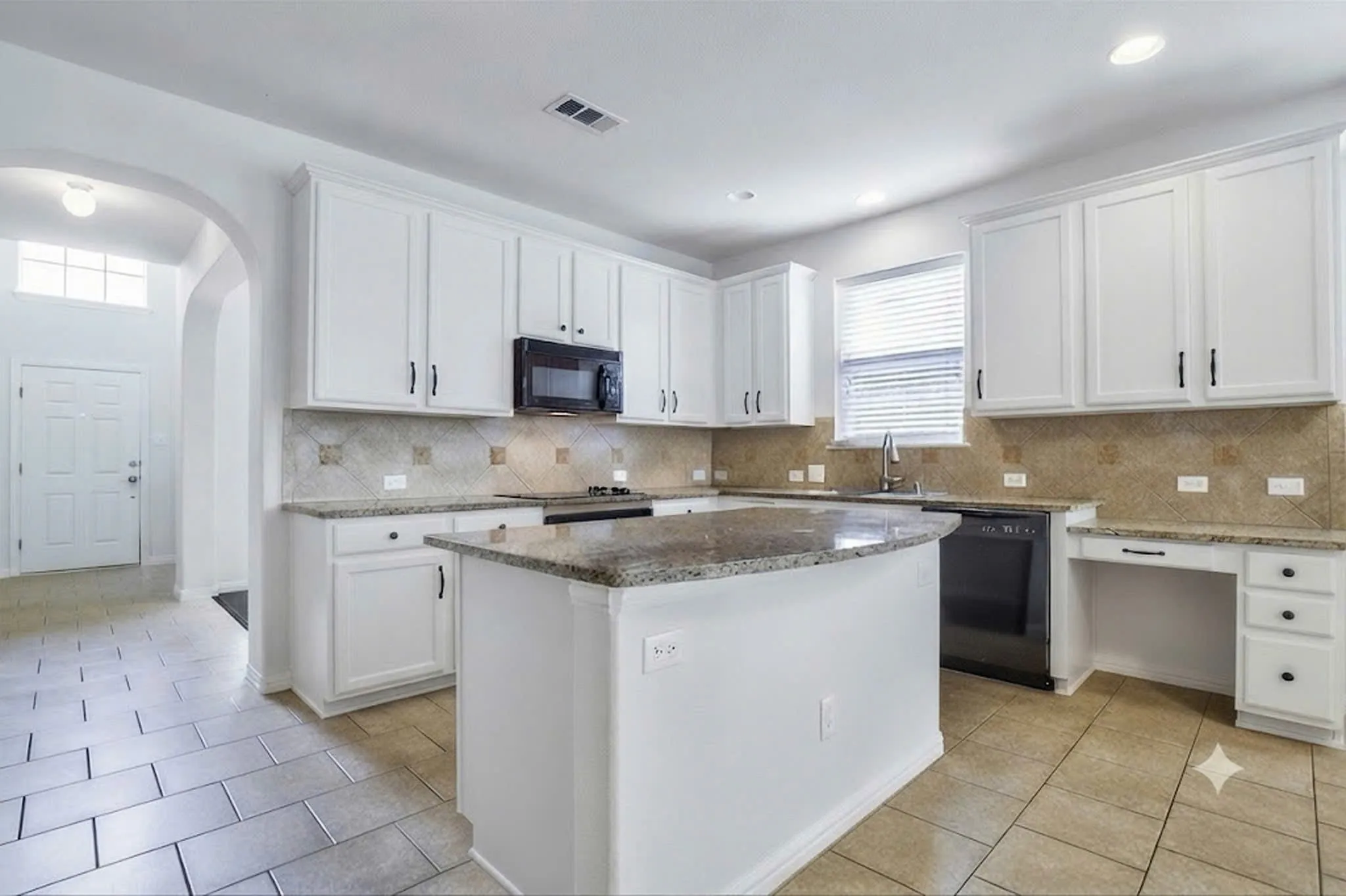 Kitchen featuring white cabinetry, granite countertops, tile backsplash, built-in microwave, and a center island