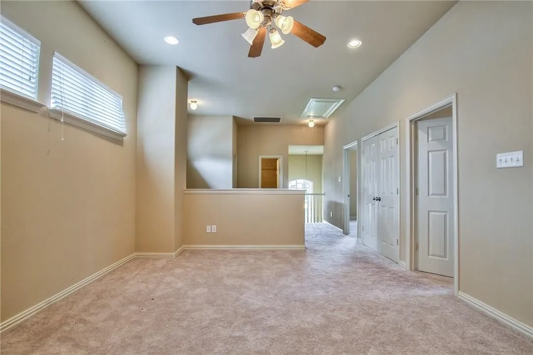 Carpeted flooring, recessed lighting, ceiling fan, multiple windows with blinds, and white interior doors