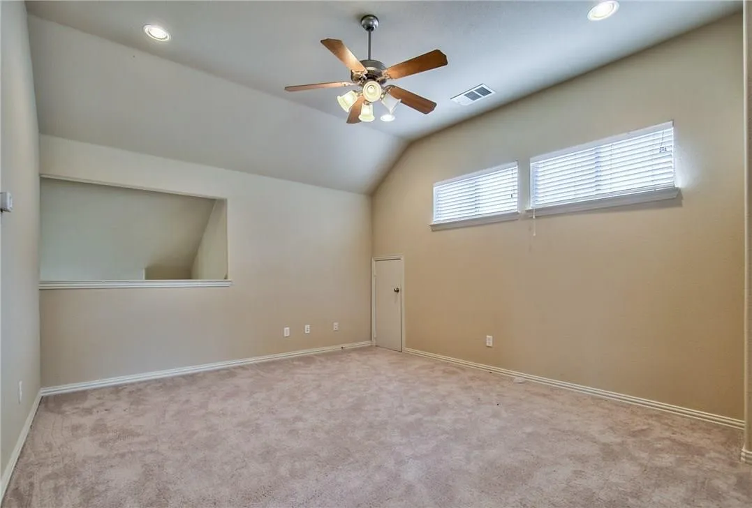 Vaulted ceiling with recessed lighting and a ceiling fan