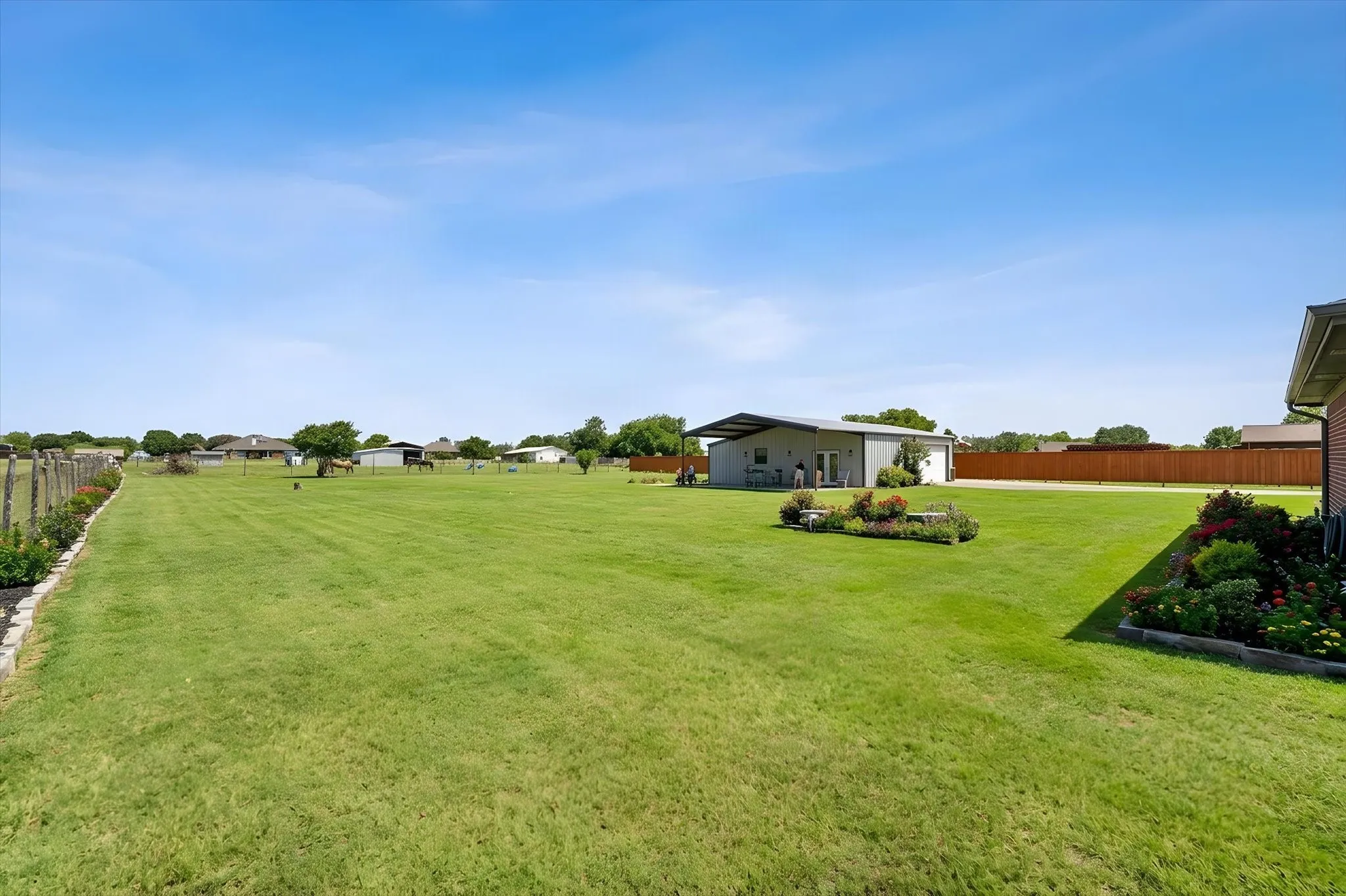 Expansive lawn area with mature landscaping and a detached auxiliary structure